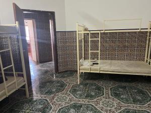 a room with a bed and a tiled floor at Beach hostel in Muscat