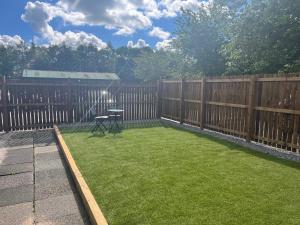 a backyard with a fence and a table and grass at Beamish Lodge in Stanley