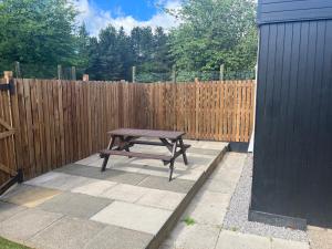 a picnic table in front of a wooden fence at Beamish Lodge in Stanley +2 photos