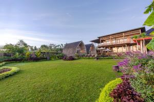 a large yard with a house and some flowers at Mountain Healing Villa by Nagisa Bali in Baturiti