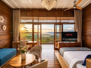 a hotel room with two beds and a table and a television at Mountain Healing Villa by Nagisa Bali in Baturiti