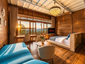 a bedroom with a bed and a table and chairs at Mountain Healing Villa by Nagisa Bali in Baturiti