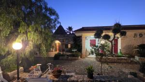 a house with chairs and a street light in a yard at Il Trulletto in Impalata