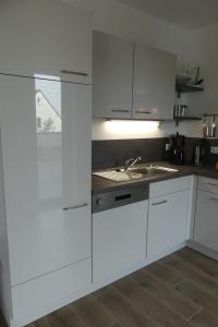 a kitchen with white cabinets and a sink at Ferienwohnung Wolkenfeld in Kaisersesch