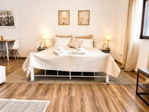 a bedroom with a white bed with towels on it at Cloud9 Airport Suites in Koropi