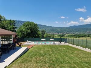 a backyard with a pool and a lawn with chairs at Casa Anto in Călimăneşti