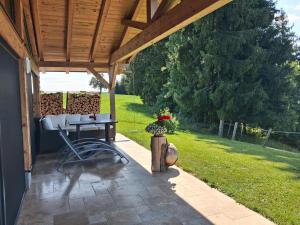 a patio with a table under a wooden roof at Almtalblick in Pettenbach