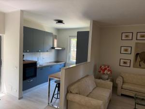 a living room with a couch and a kitchen at Casa MAREVERDE con aria condizionata in Punta Ala