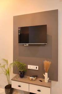 a room with a tv on a wall with plants at OddbirdStays in Indore