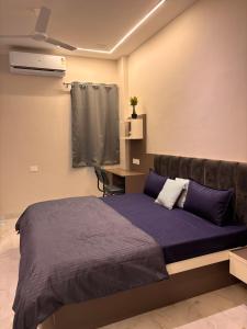 a bedroom with a bed and a desk in it at OddbirdStays in Indore
