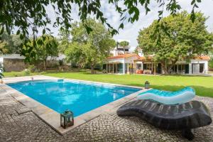 a swimming pool in a yard with a house at Charming House in Cascais in Alcabideche
