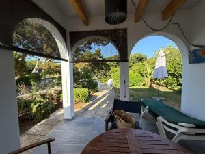 a patio with a table and a view of a yard at Xalet Son Favaritx by GMHouse Menorca in Cala en Bosc