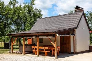 a large white shed with a table in it at LIKe A cottage in Perušić