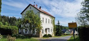 a white building with a sign on the side of a road at Alte Schule in Bad Brambach