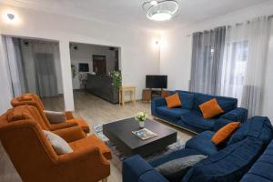 a living room with blue couches and orange chairs at Rusal Haven in Rubavu