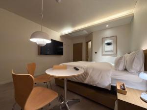 a hotel room with a bed and a table and chair at SODO Hotel in P'aju