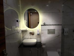 a bathroom with a sink and a mirror at Pahadi Sukoon - A frame Cottages in Dharamshala