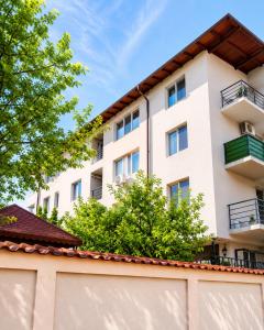 a white building with trees in front of it at ARKADIA 2 BR APARTMENTs in Bucharest