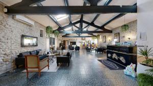 a lobby with couches and chairs in a building at L'Escale des Alpilles in Rognonas