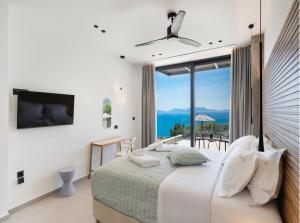 a bedroom with a bed with a view of the ocean at Eleage Villas in Lefkada