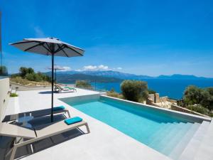a villa with a swimming pool and an umbrella at Eleage Villas in Lefkada
