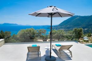 a patio with a table and chairs and an umbrella at Eleage Villas in Lefkada