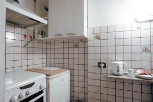 a small kitchen with white tiled walls and white cabinets at Al Vecchio Convento in Portico di Romagna +55 photos