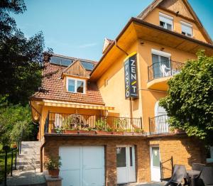 a building with two garage doors in front of it at Zenit Panzió in Miskolctapolca