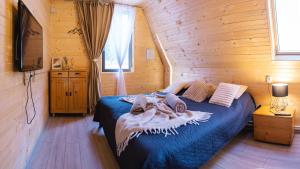 a bedroom with a bed in a wooden cabin at Escape Remeti - Aframe by the River in Remeţi