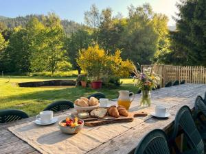 a wooden table with a tray of bread and drinks at Domaine de Marmonfosse in Taintrux