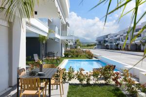 an outdoor patio with a table and chairs next to a swimming pool at Green Almond Residential Complex in Orfánion