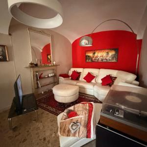 a living room with a white couch and a red wall at Oasi di pace in Romano Canavese