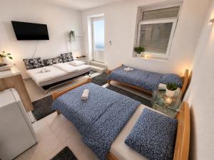 a living room with two beds and a couch at Apartmani Velić in Bugojno