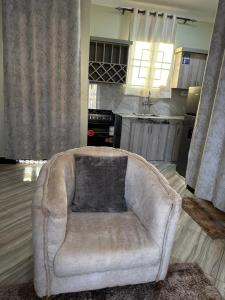 a couch in a living room with a kitchen at El SALI APPARENT,Najjera in Namugongo +3 photos