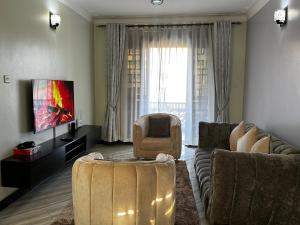 a living room with a couch and a chair at El SALI APPARENT,Najjera in Namugongo