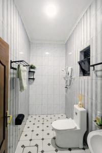 a white bathroom with a toilet and a sink at Rusal Haven in Rubavu +28 photos