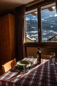 a table with a plate and a bottle of wine at Chalet Meridiana in Bormio