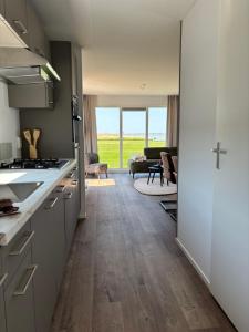 an open kitchen with a view of a living room at Chalet Wad'n Droom in Westerland
