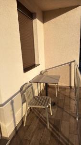 a table and a chair on a balcony with a table at Apartman ML Company in Bečići