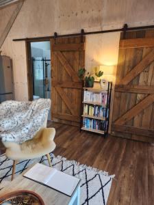 a living room with wooden doors and a book shelf at Warkworth Barn Retreat in Warkworth