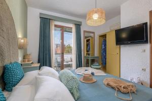 a living room with a couch and a tv at Casa Dell Artista with private jacuzzi in Kos
