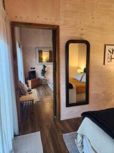 a bedroom with a large mirror and a bed at Warkworth Barn Retreat in Warkworth