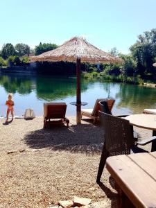 a child is standing in front of a lake at Relax House EMB in Čapljina