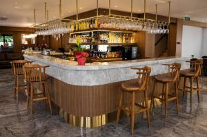 a bar in a restaurant with wooden stools at Alpek Hotel Antalya - Lara in Antalya