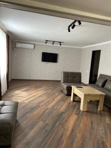 a living room with two couches and a coffee table at Kostas guest house in Borjomi