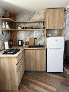 a kitchen with wooden cabinets and a white refrigerator at Kostas guest house in Borjomi