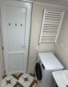 a washing machine in a bathroom with a white door at Kostas guest house in Borjomi +3 photos