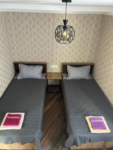 two beds sitting next to each other in a room at Kostas guest house in Borjomi