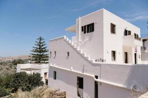 a white house with stairs on the side of it at Iliaxtida apartments II in Grámousa
