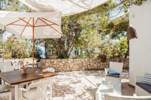 a patio with a table and an umbrella at Casa Bianca Rais Gerbi in Finale